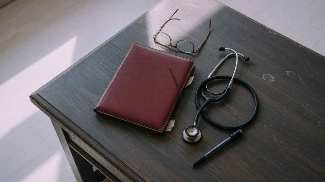 Prontuário médico e estetoscópio sobre mesa de escritório de advocacia